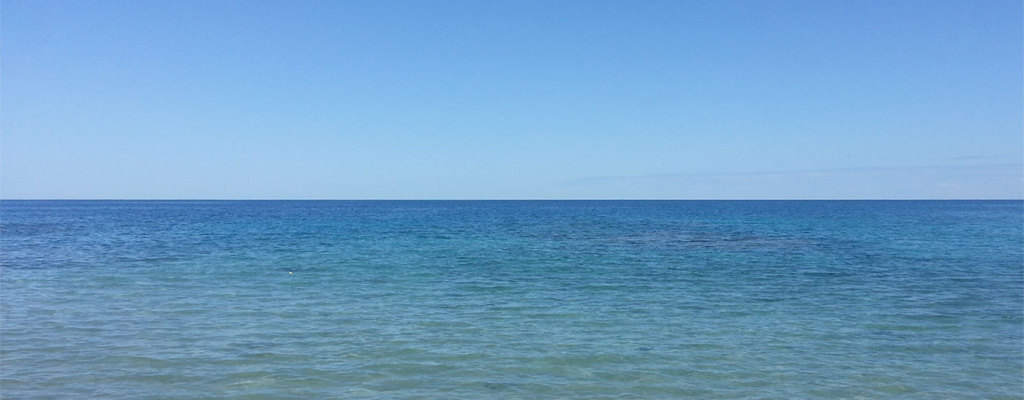 Calm seawater beneath a clear sky